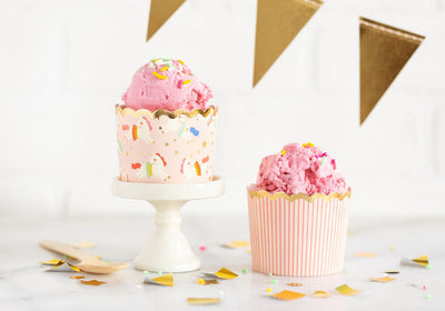 gold star banner hangs over a bunny doll and a cupcake in a pink and gold cupcake cup with a white moon on it