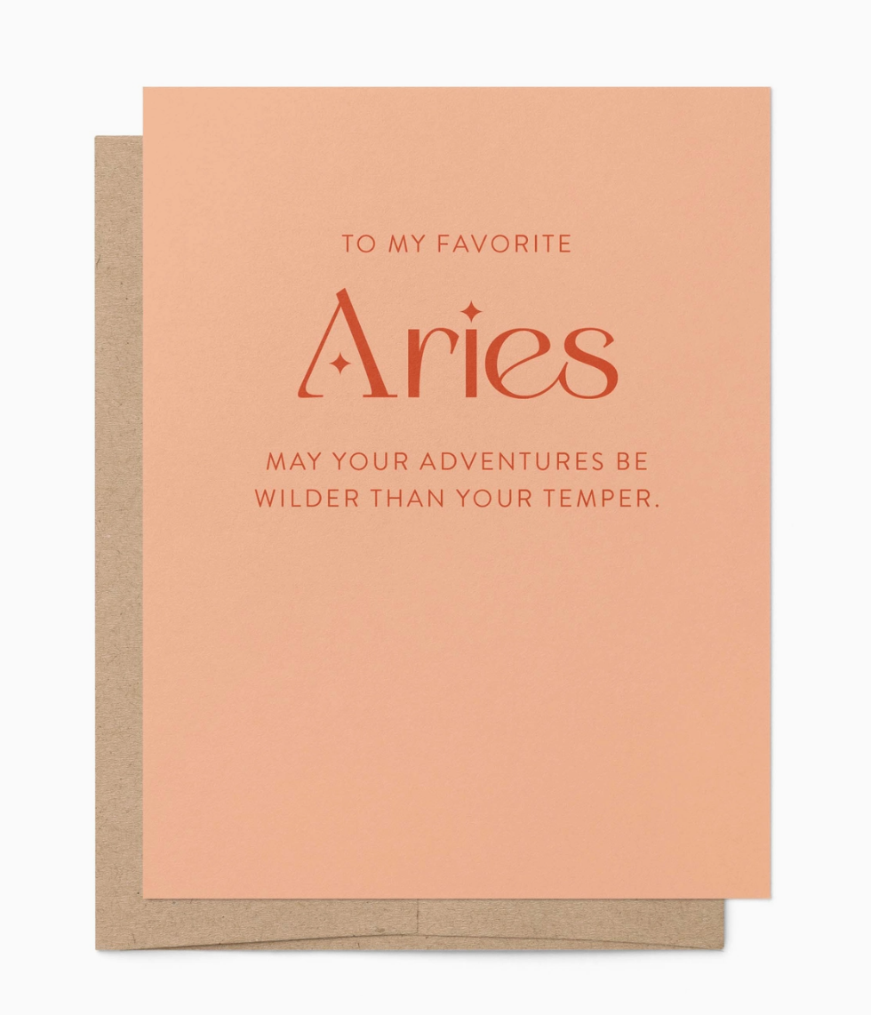Peach greeting card with the text "to my favorite Aries, may your adventures be wilder than your temper" with a brown envelope