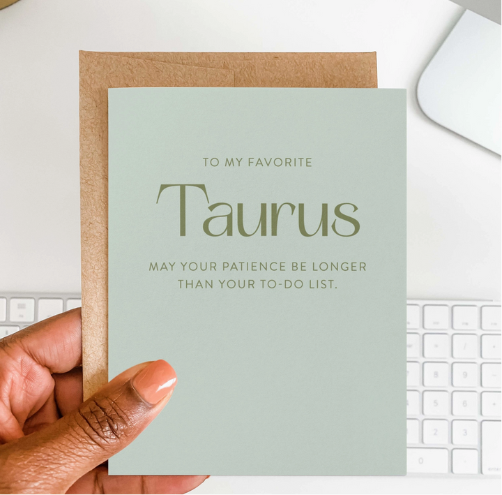 Hand holding a light green greeting card with text &