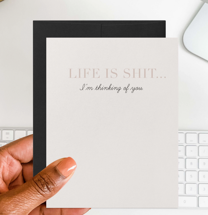 Hand holding a white greeting card with &
