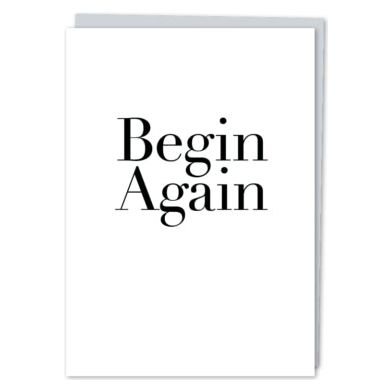 White greeting card with black text that reads "begin again" paired with a metallic silver envelope