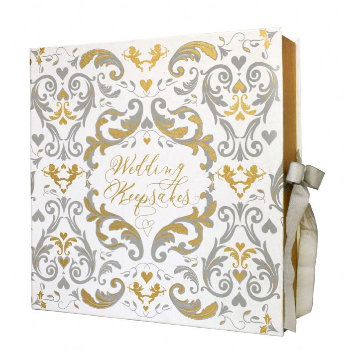 White book with screen-printed baroque style pattern in grey and gold. The text "wedding guests" in gold in center of book, grey ribbon bow on side