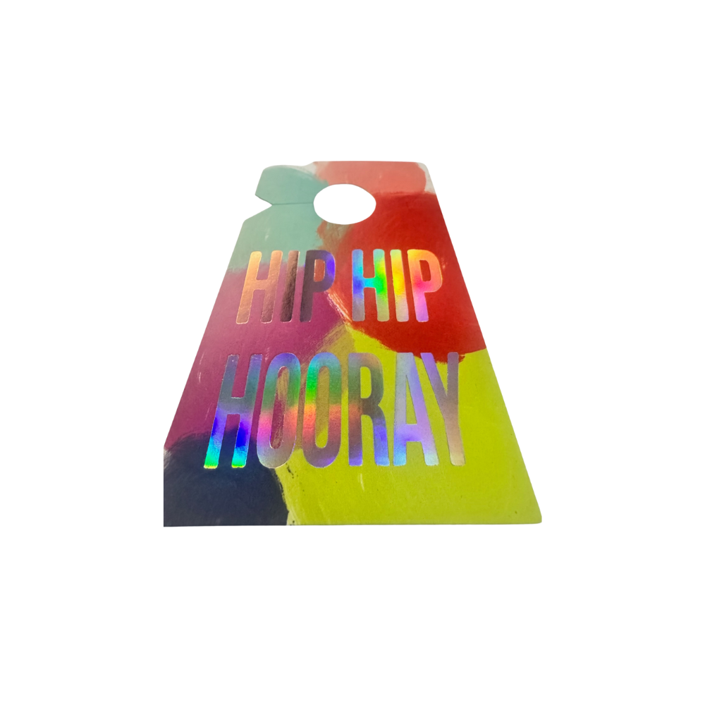 Close up of a neon red, aqua, pink, fuchsia, and green splash print on a beard clip style gift tag with an iridescent foil print that reads Hip Hip Hooray.