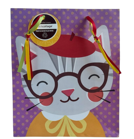 Purple gift bag with yellow polka dots and a smiling kitten wearing a red beret hat, glasses, and a cozy orange sweater. Multi-strand ribbon handles in red, yellow, and green and yellow gift tag