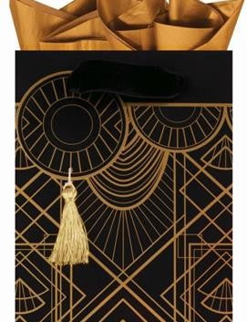 Close up of a black wine bottle bag with gold art deco-inspired print pattern, gold tassel, black velvet handles, and gold tissue paper