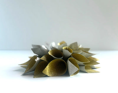 Side view of a glitter gold and silver lotus flower style gift bow