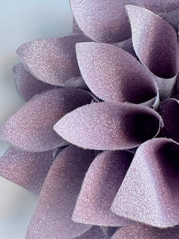 Close up view of a glittery lavender and silver colored gift bow