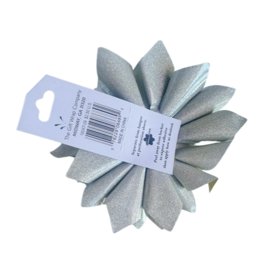 Back side of a Glittery silver colored lotus shaped gift bow with a product tag