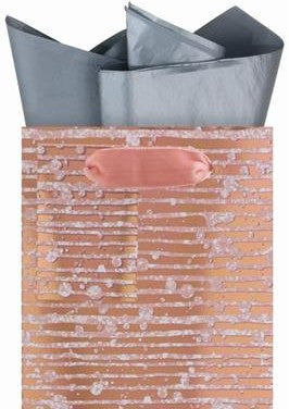 Close up of a metallic rose gold and silver abstract stripes wine bottle gift bag with silver tissue paper and rose gold ribbon handles