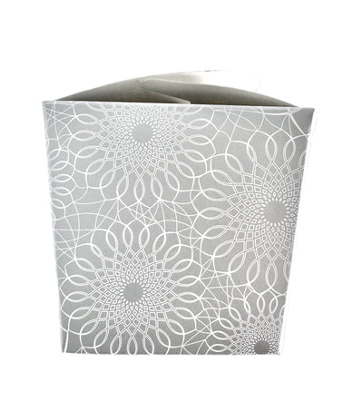 A close-up image of a silver take-out style box with an allover white printed scroll pattern.