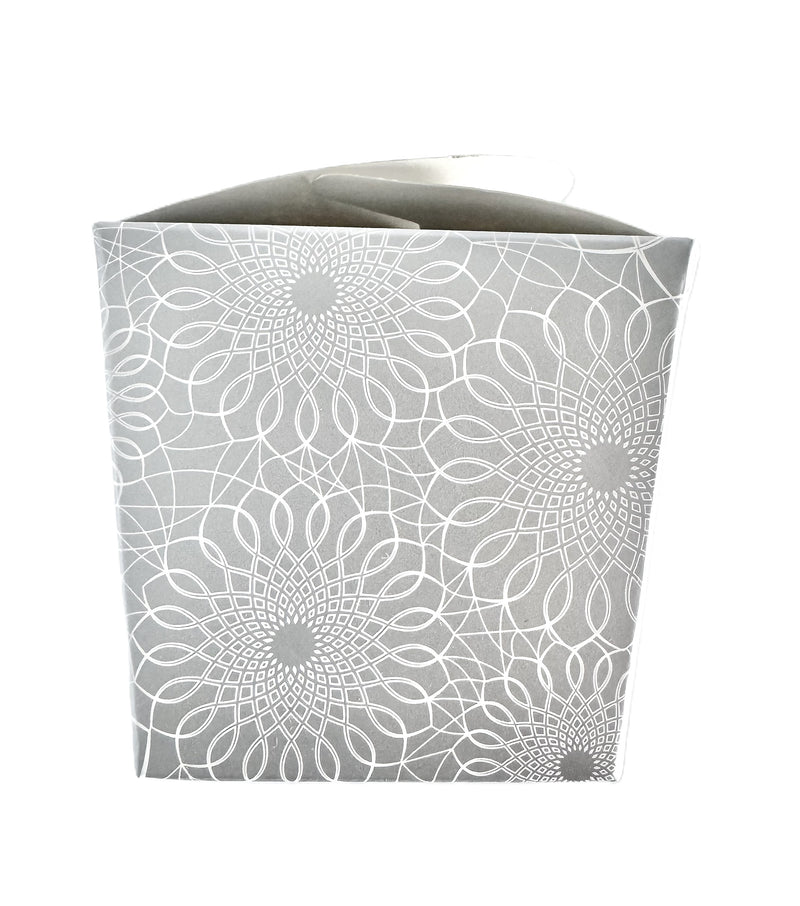 A close-up image of a silver take-out style box with an allover white printed scroll pattern.