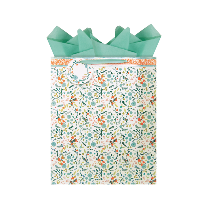 teal, blush, orange, and green all over floral print patterned extra-large gift bag with teal tissue paper and a matching gift tag.