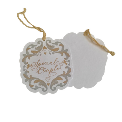 White gift tag with Baroque inspired shape and silver and gold print art detail and gold ribbon. Backside is blank