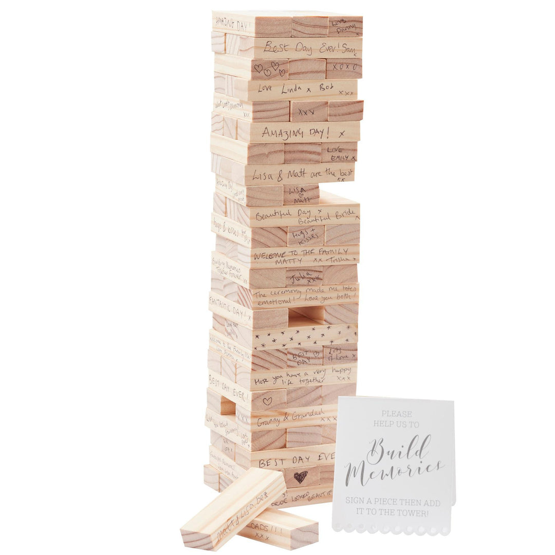 Wooden block tower with engraved messages and a card on a white background