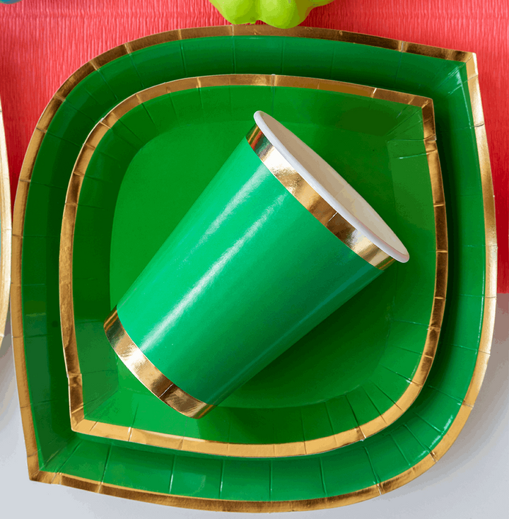 stack of green with gold foil border charger plate, dinner plate, paper cups