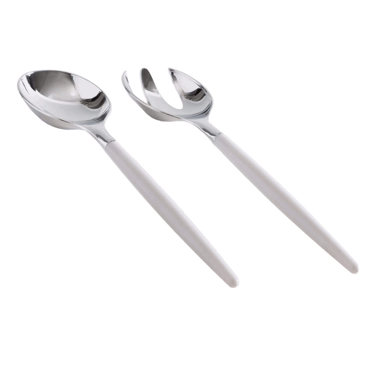 White background, a side view of a white-handled salad serving set with silver tops lying down. 1 salad serving fork next to 1 salad serving spoon.
