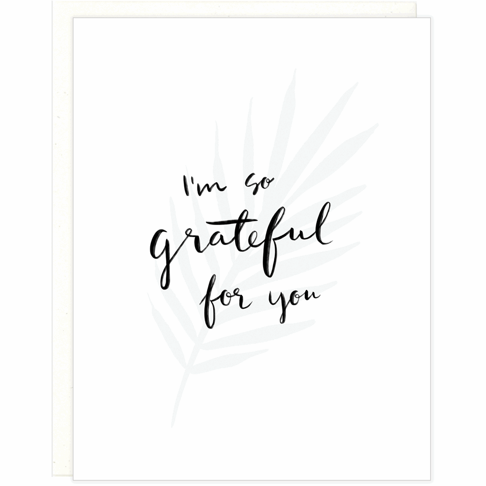 White greeting card with black text that reads "I'm So Grateful For You" over a letterpress fern stem with a white envelope