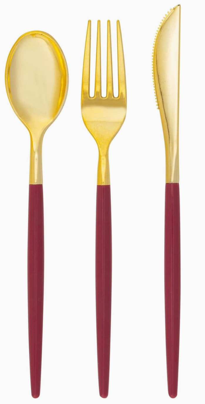 white background with cranberry color handle with gold cutlery set, showing a spoon, fork, and knife