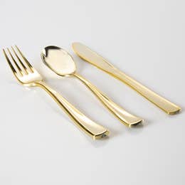 A set of gold plastic cutlery including forks, spoons, and knives laid out on a white background.