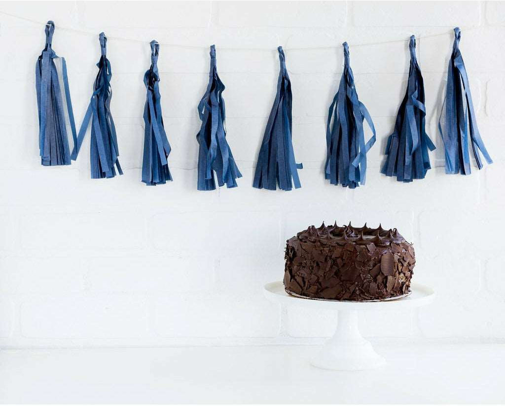 Navy blue Tassel style Banner above a chocolate cake on a white cake stand