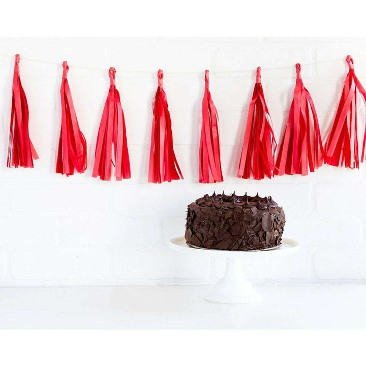 Cherry red Tassel style Banner above a chocolate cake on a white cake stand