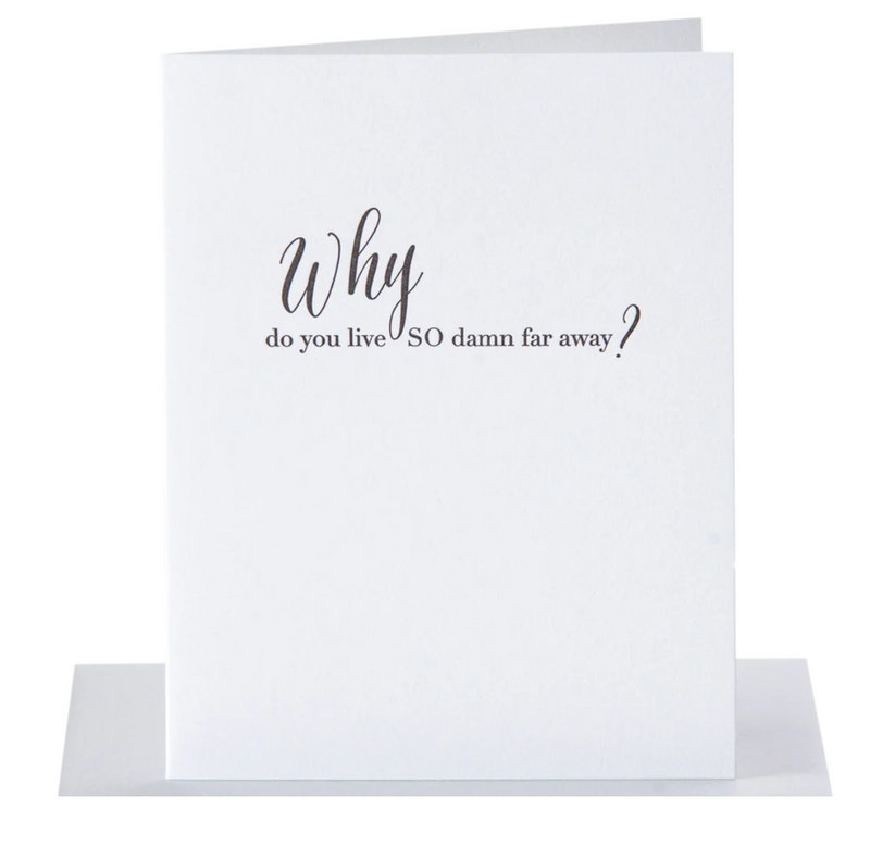 grey envelope lying flat on a white background with a white greeting card standing upright on top with the inscription White do you live so damn far away? in black font