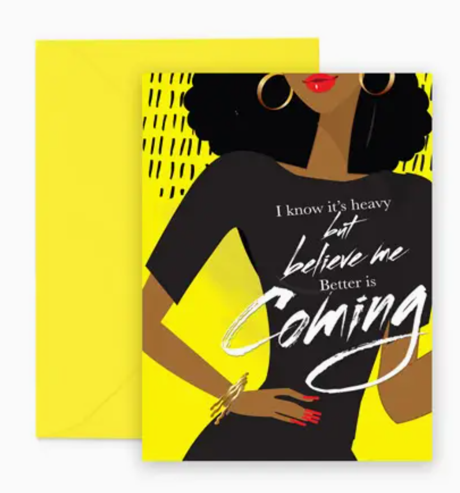A bright yellow greeting card featuring an illustration of a woman with the text that reads 'I know it’s heavy but believe me, Better is Coming' printed on the woman's black dress