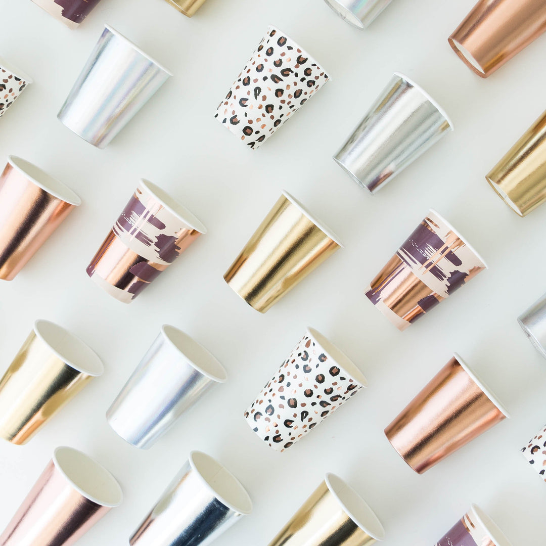 Diagonal rows of paper cups in different colors, finishes and patterns on them.