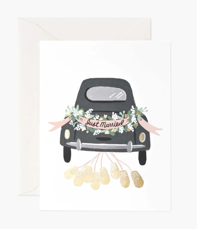 greeting card with an illustration of the back of a black vintage car with floral decorations and a &