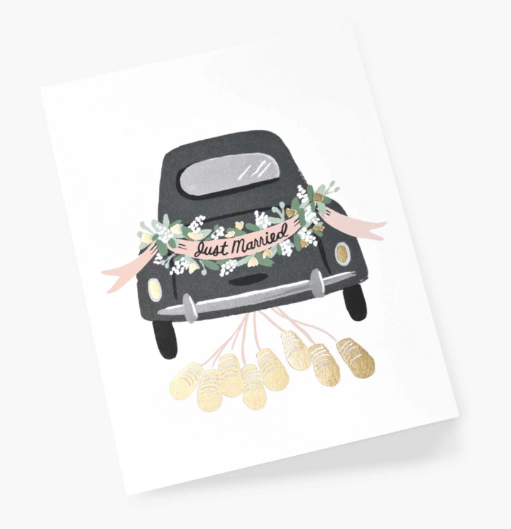 greeting card with an illustration of the back of a black vintage car with floral decorations and a &