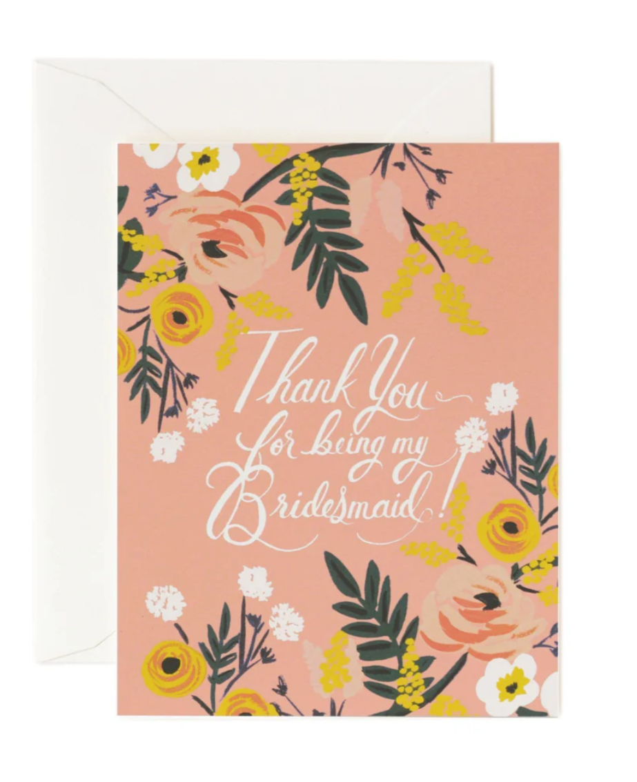 Coral-colored greeting card with multi-color floral design and text 'Thank you for being my bridesmaid?' with a cream envelope