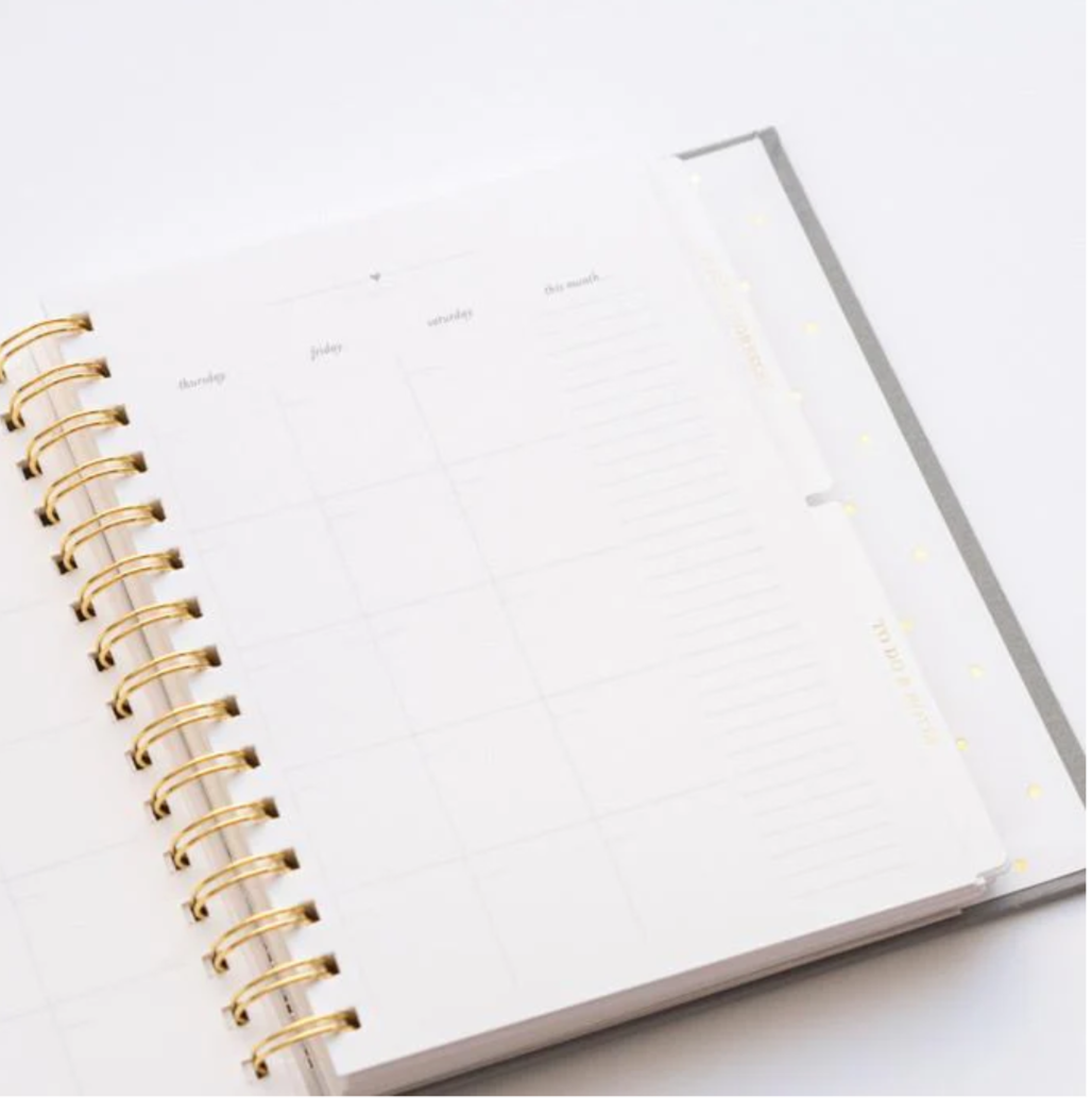 Open notebook with gold spiral binding on a white background