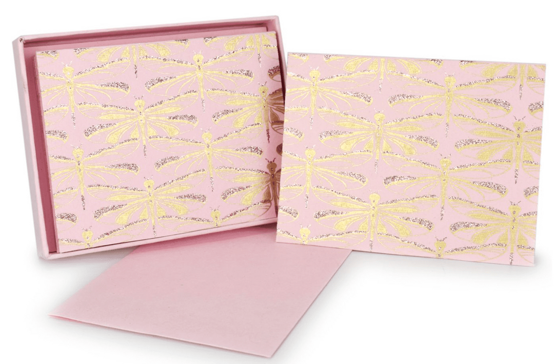 Blush pink greeting card with all-over gold and rose gold foil printing of rows illustrated dragonflies shown as a boxed set.