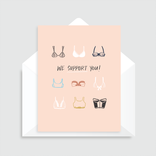 Blush pink greeting card with illustrations of different bra styles and colors (3 rows with 3 bras each row) and the text "We support you", paired with a white envelope