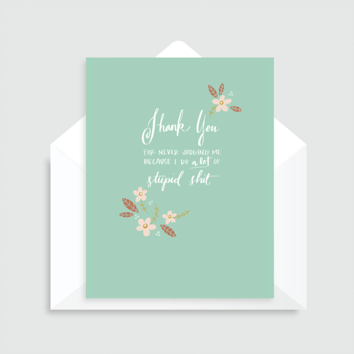 Green greeting card with illustrated flowers and white text that reads "Thank you for never judging me because I do a lot of stupid shit". Paired with a white envelope