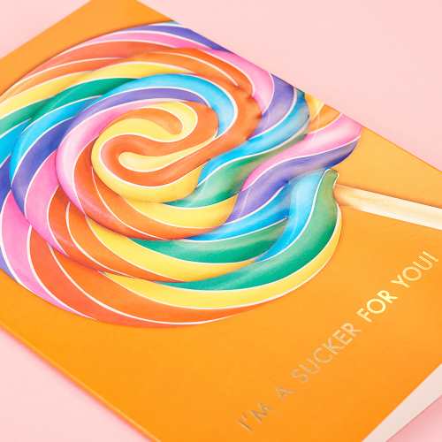 Vibrant orange greeting card with a large rainbow swirl lollipop with gold-foil text reads "I&