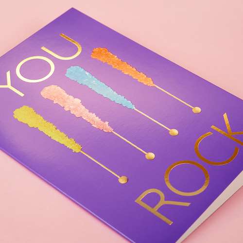 Vibrant purple greeting card, with a picture of 4 pop rock candies and text "You Rock" in gold foil
