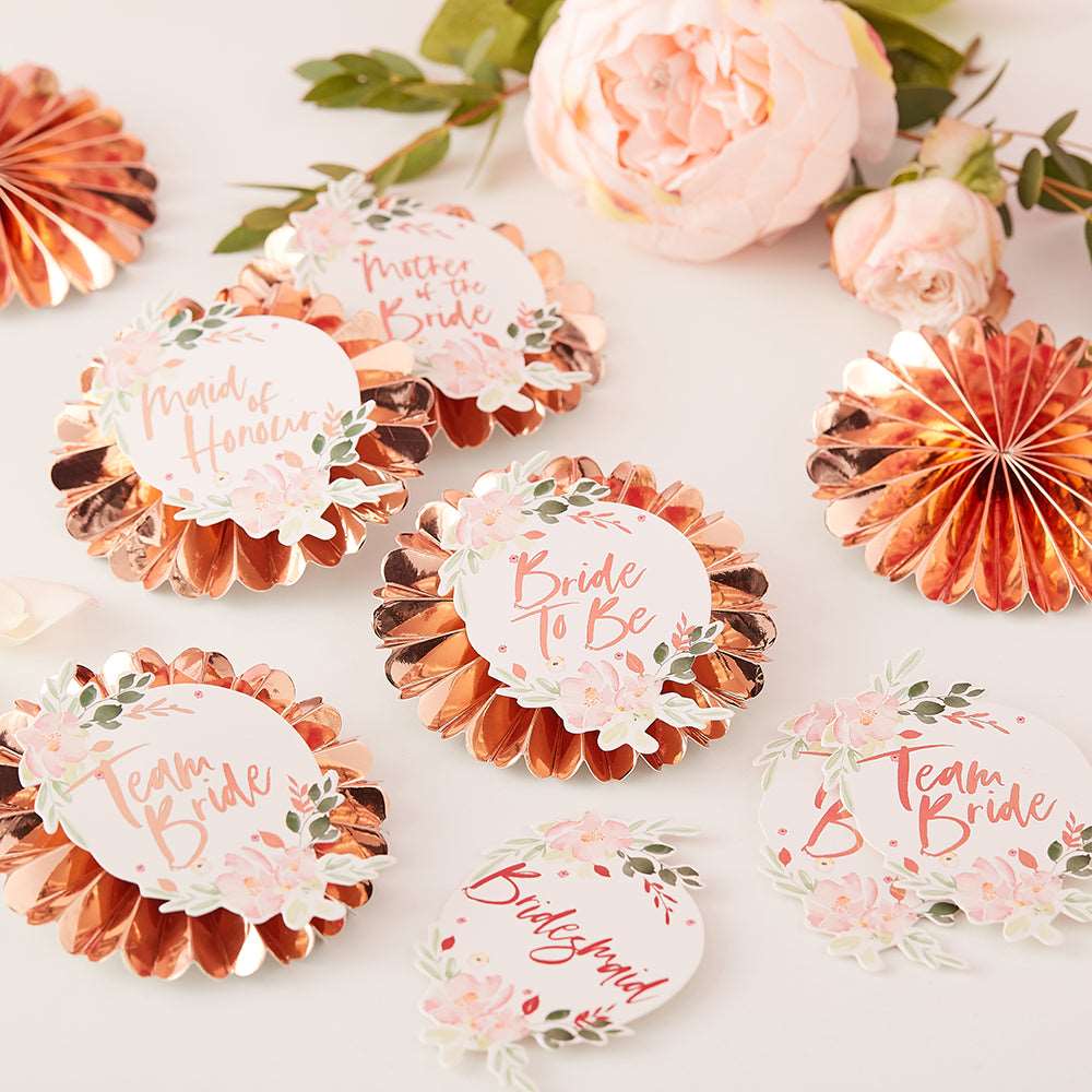 Rose gold pin badges with floral stickers, customized with various titles such as &