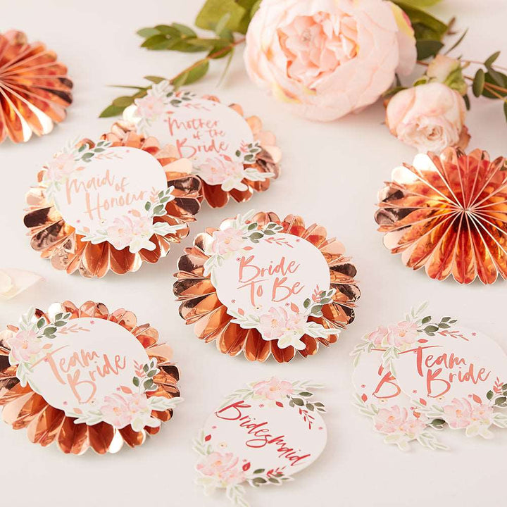 Rose gold pin badges with floral stickers, customized with various titles such as &