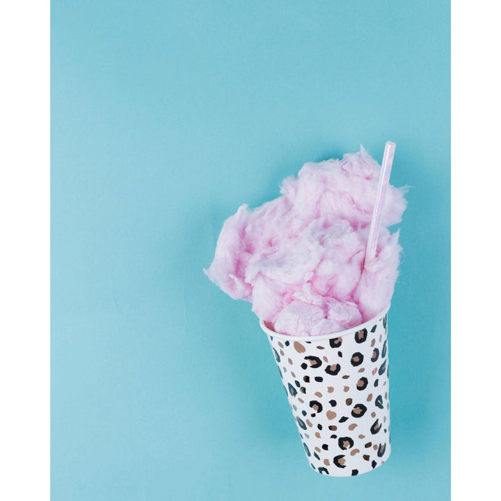 Blue background, animal print paper cup with cotton candy and an iridescent paper straw in it.