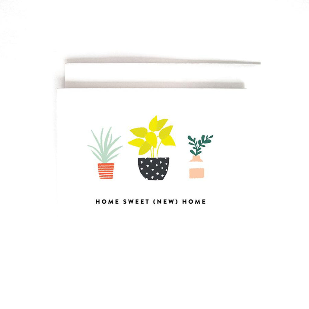 White greeting card featuring colorful illustrations of potted plants and the text "HOME SWEET (NEW) HOME" with a white envelope