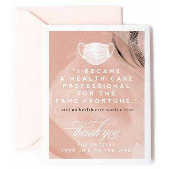 Abstract print blush pink, cream, and black greeting card with an image of a face mask at the top followed by text that reads - "I BECAME A HEALTH CARE WORKER FOR THE FAME &amp; FORTUNE," - said no health care professional ever. Thank you for putting your life on the line!" and a pale peach envelope on a white background