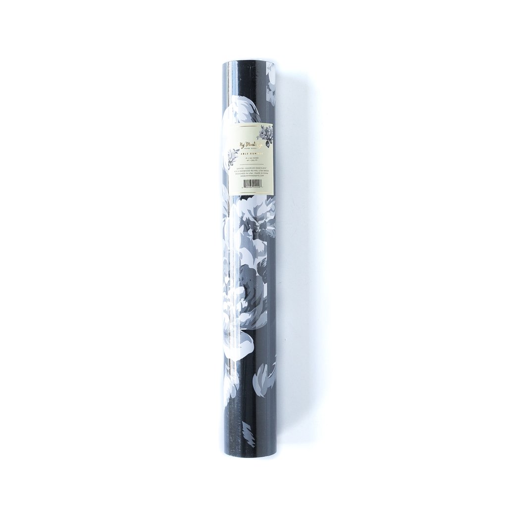 A packaged black and white floral patterned paper table runner.