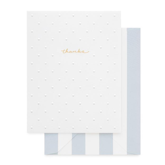 White greeting card with allover embossed dots and letterpress gold foil text "thanks". Paired with a sky blue and white striped envelope