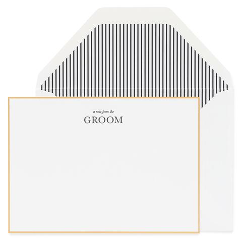 White notecard with gold foil border and black text that reads a note from the groom paired with a white envelope with black and white striped liner