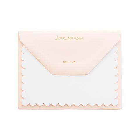 White scalloped edge note card, paired with a blush pink envelope with gold foil letterpress inscription on outside back flop that reads "From My Post To Yours" and an arrow